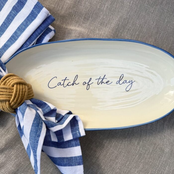 hvit ovalt fat med blå kant, med teksten catch of the day fra Bruka design